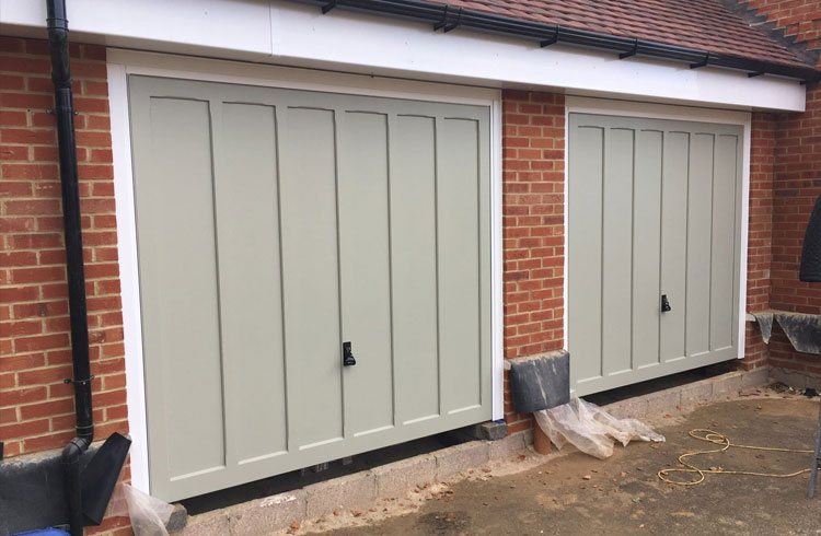 Two Churchill style timber garage doors  in colour match Farrow and Ball French Grey with White steel frames