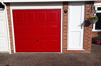 A Garador Georgian style Red up and over Garage Door with a White steel frame and White PVC fascia. Fitted in Farnborough. Hampshire.