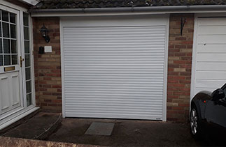 A Gliderol 55mm Compact insulated roller shutter garage door in White. Fitted in Light Water. Surrey.