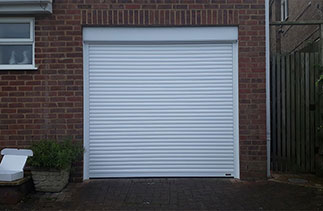 A Sws Seceuroglide 55mm Compact Insulated Roller Shutter Garage Door in White. Fitted in High Wycombe, Buckinghamshire. This door is exposed to strong winds and had a timber and Pvc Fascia built to fix the Fascia of the door to. To prevent it rattling in the wind.