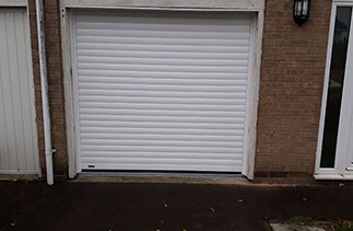 A Sws Seceuroglide Excel Insulated Roller Shutter Garage Door in White. Fitted to the existing timber frame in Basingstoke, Hampshire. The existing timber frame to be clad in White PVC.