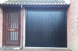 A set of Garador steel range side hinged garage doors in a 2/3rd 1/3rd arrangement in Black. These doors are supplied with extra security. Fitted in Walton On Thames, Surrey.