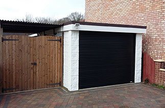 A Black Gliderol compact insulated roller shutter garage door fitted in Ashvale, Surrey.