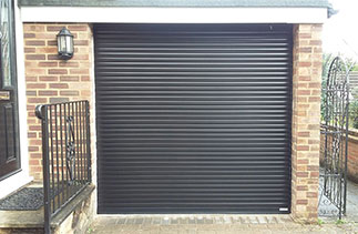 A Gliderol 55 compact Black roller shutter garage door fitted with matching guides and a matching full box. Fitted in Mytchett, Surrey.