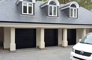 Three Garador Linear Large Black sectional garage doors fitted behind the existing timber frames supplied with Garador Garamatic 10 belt driven electronic operators. The operators were linked in to the gates so one hand transmitter could open the electronic gates and the garage doors. These door were sent out with Hormann badges but are ordered through Garador. Doors fitted in Egham, Surrey.