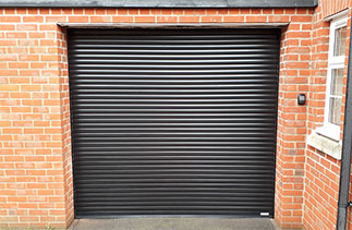 A Gliderol 55mm compact Black insulated roller shutter garage door fitted with a external wireless key pad. Garage door fitted in Basingstoke, Hampshire.