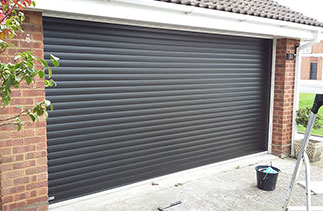 A Seceuroglide Excel roller shutter garage door in Black wood grain. This door is supplied on white slats so from inside the back face of the door is white. Fitted in Berkshire.