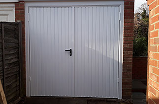 A set of Garador steel side hinged Carlton style garage doors in white. Fitted near Farnham, Surrey.