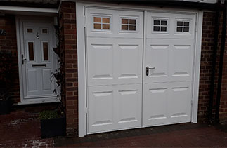 A set of Garador steel side hinged garage doors in the Beaumont style with windows.