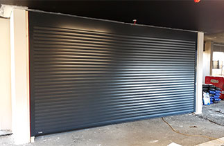 A Sws Seceuroglide Excel double Roller shutter garage door in Anthracite Grey with a full box and fitted within the opening. This door has box supports and a external release drilled through the guide. Garage door fitted in Virginia Water, Surrey.