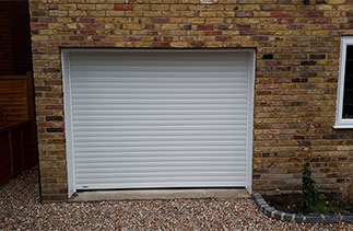 A Sws Seceuroglide Excel in White with White UPVC over the brick faces and underside of the steel lintel. Garage door fitted in Woking, Surrey.