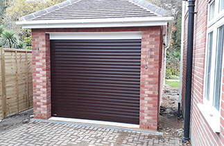 A Mahogany Sws Seceuroglide Excel insulated roller shutter garage door with a White 90 degree half top box. Fitted in Fleet, Hampshire.