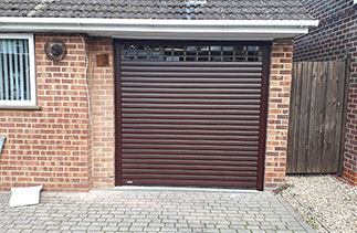 A Sws Seceuroglide roller shutter garage door in Mahogany with vision slats. Fitted in Camberley, Surrey.