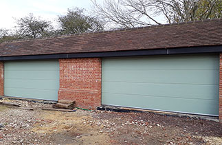 Two Carteck GSW 40-L Solid ribbed sectional garage doors in Chartwell Green Wood Grain finish. Fitted in Bramley, Nr Guildford, Surrey.