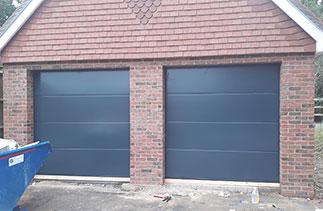 Two Garador Linear Large premium silk grain sectional garage doors in Anthracite grey with No branding badges. Doors fitted in Cranleigh, Surrey.