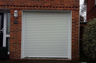 A White Seceuroglide Excel roller shutter garage door fitted behind the lintel and within the brick work. Complete with White upvc on the brick faces. Fitted in Reading, Berkshire.